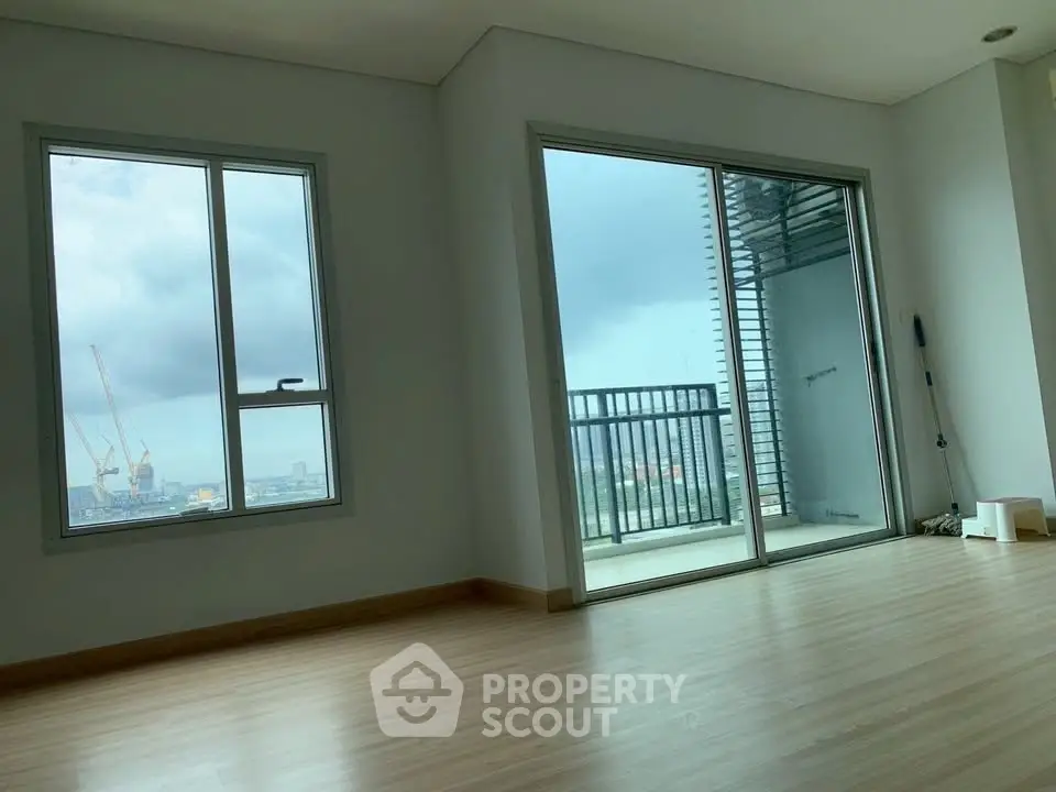 Spacious apartment with large windows and balcony offering stunning city views.