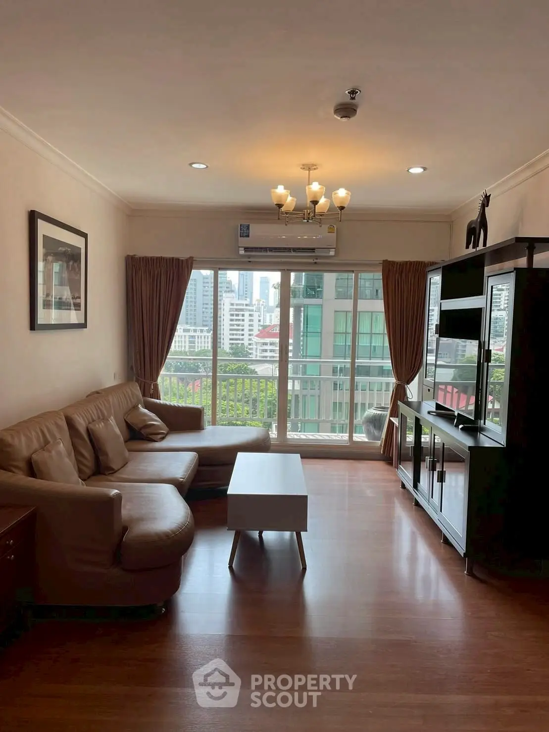 Spacious living room with city view, elegant furniture, and natural light.