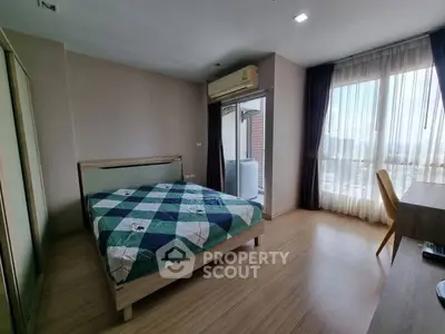 Spacious bedroom with large window and modern furnishings