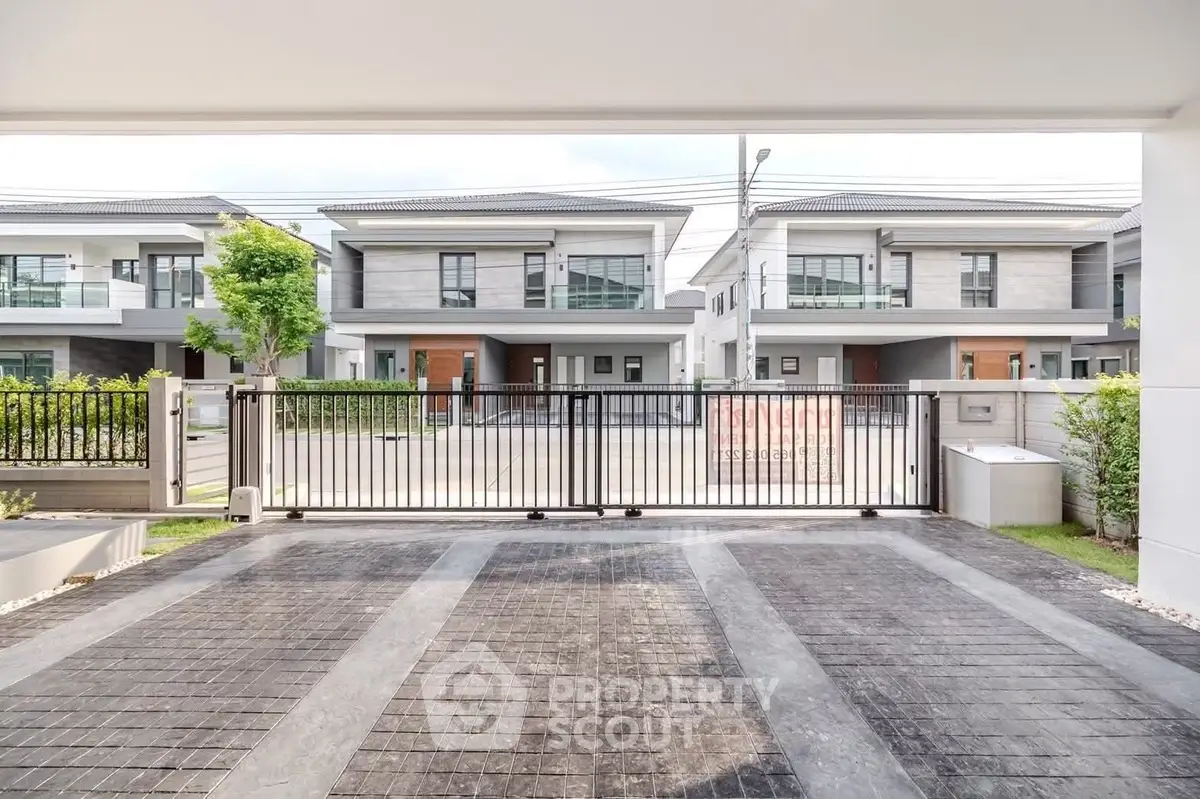 Modern residential neighborhood with stylish houses and gated driveway.