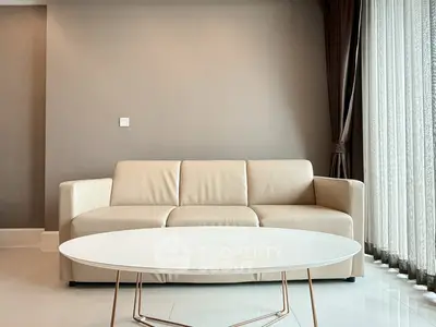 Modern living room with beige sofa and round white coffee table