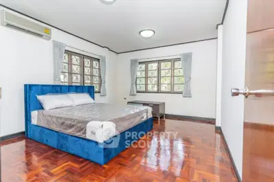 Spacious bedroom with hardwood floors and large windows for natural light.