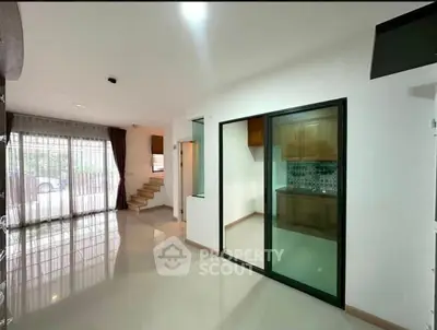 Spacious open-plan living area with modern kitchen and large windows for natural light.