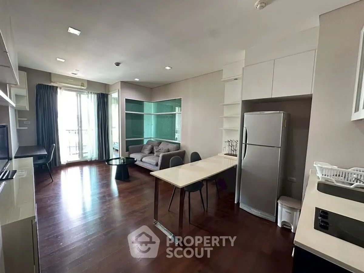 Modern living room with open kitchen and balcony access in a stylish apartment.