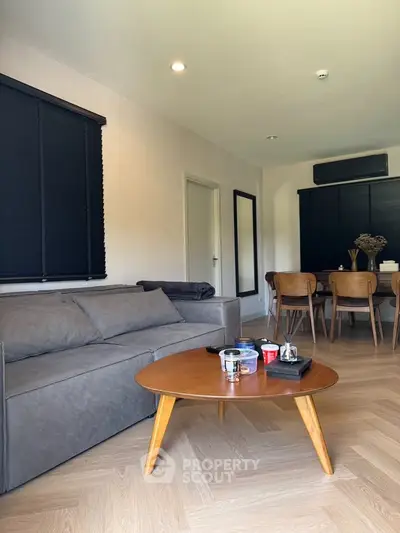 Modern living room with stylish furniture and dining area, featuring a cozy ambiance.