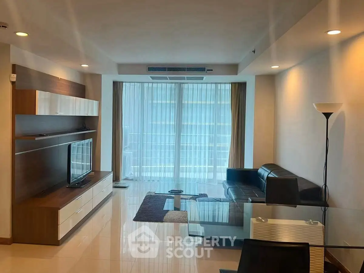 Modern living room with sleek furniture and large windows offering natural light.