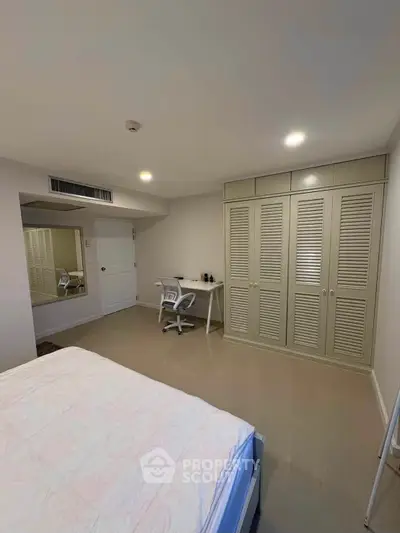 Spacious bedroom with built-in wardrobe and study desk, perfect for modern living.