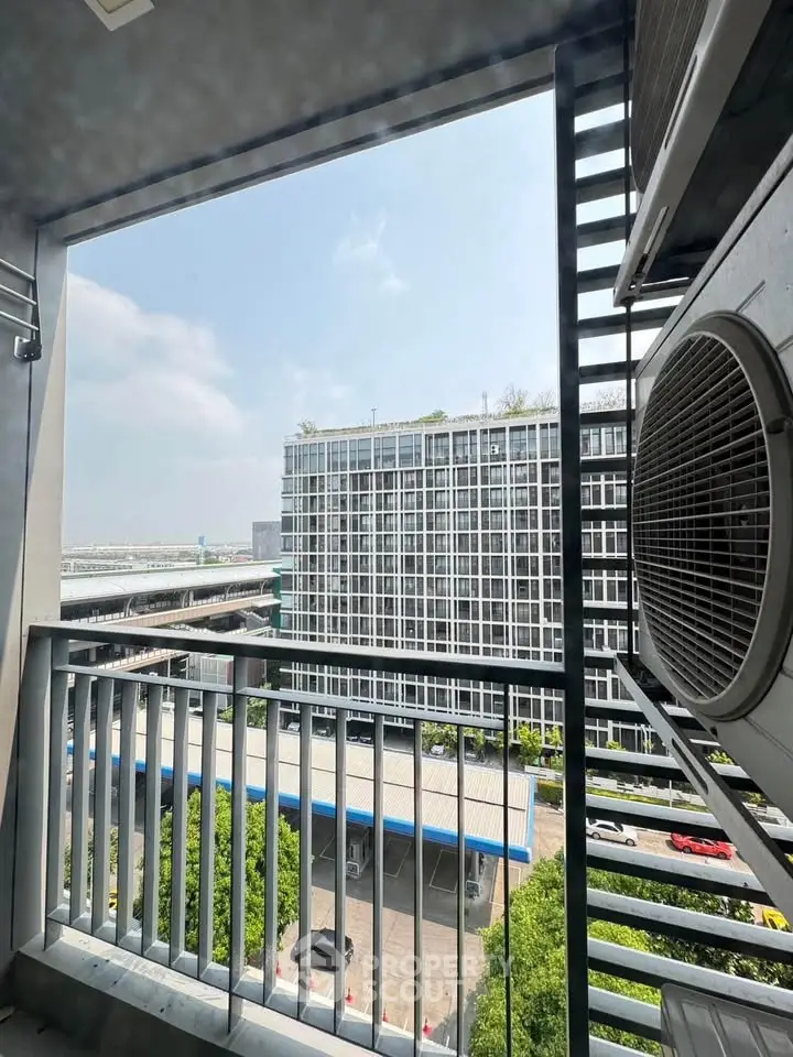 Modern urban view from a balcony with cityscape and building facade.