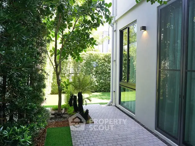 Charming garden pathway with lush greenery and modern exterior design.