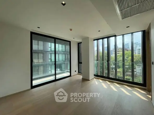 Spacious modern living room with large windows and city view, perfect for urban living.