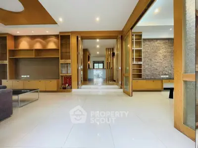 Spacious modern living room with elegant wooden accents and ample natural light