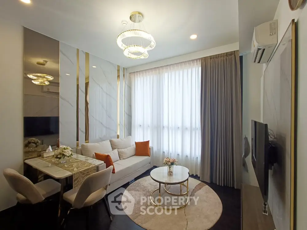Elegant living room with modern decor, featuring a cozy sofa, stylish chandelier, and large window for natural light.