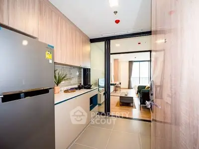 Modern kitchen with sleek design and open layout leading to a bright living area.