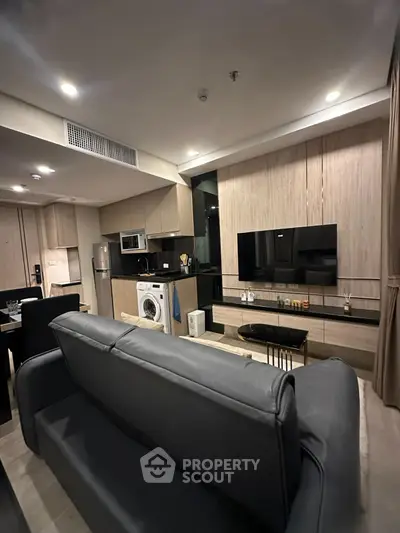 Modern living room with sleek furniture and integrated kitchen appliances