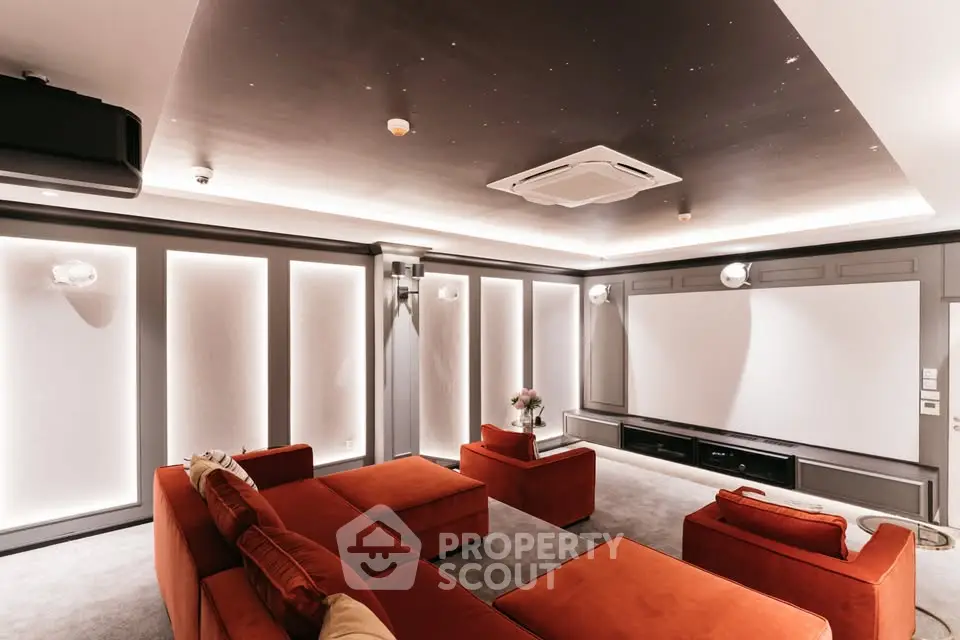 Luxurious home theater with plush red seating and ambient lighting for ultimate entertainment experience.