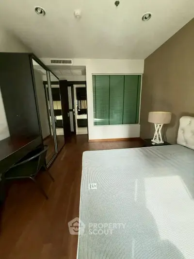 Spacious bedroom with modern decor and large mirror wardrobe