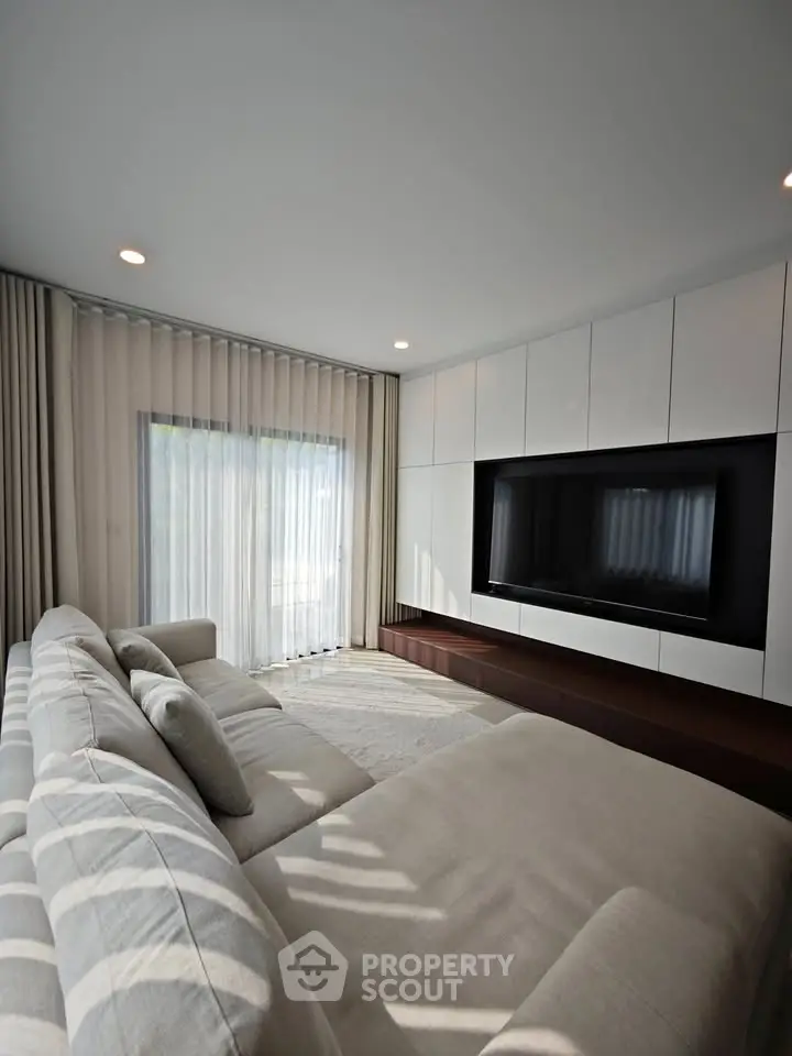 Modern living room with sleek built-in entertainment center and cozy sectional sofa.