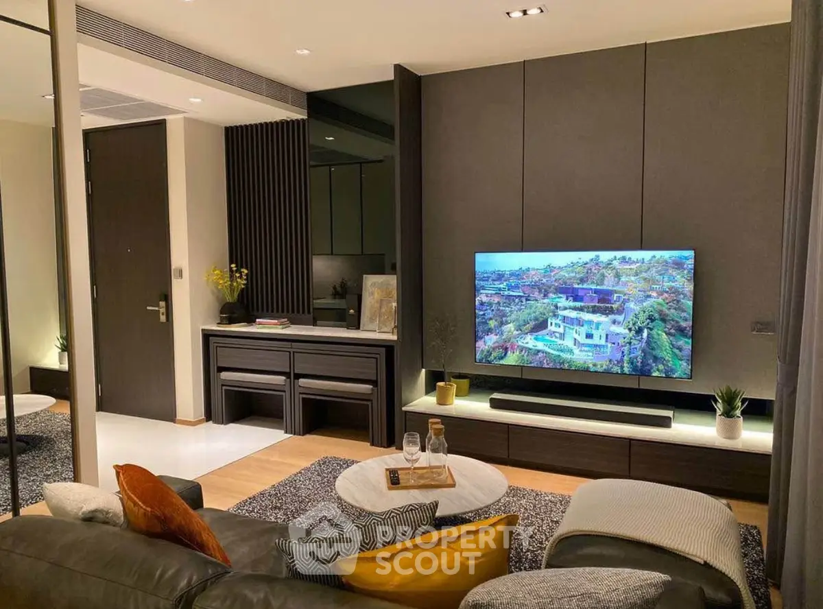 Modern living room with sleek design, large TV, and cozy seating area.