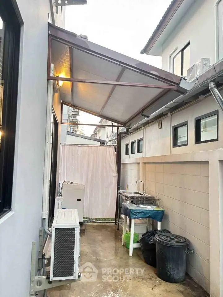 Charming side alley with covered utility area in modern home exterior.