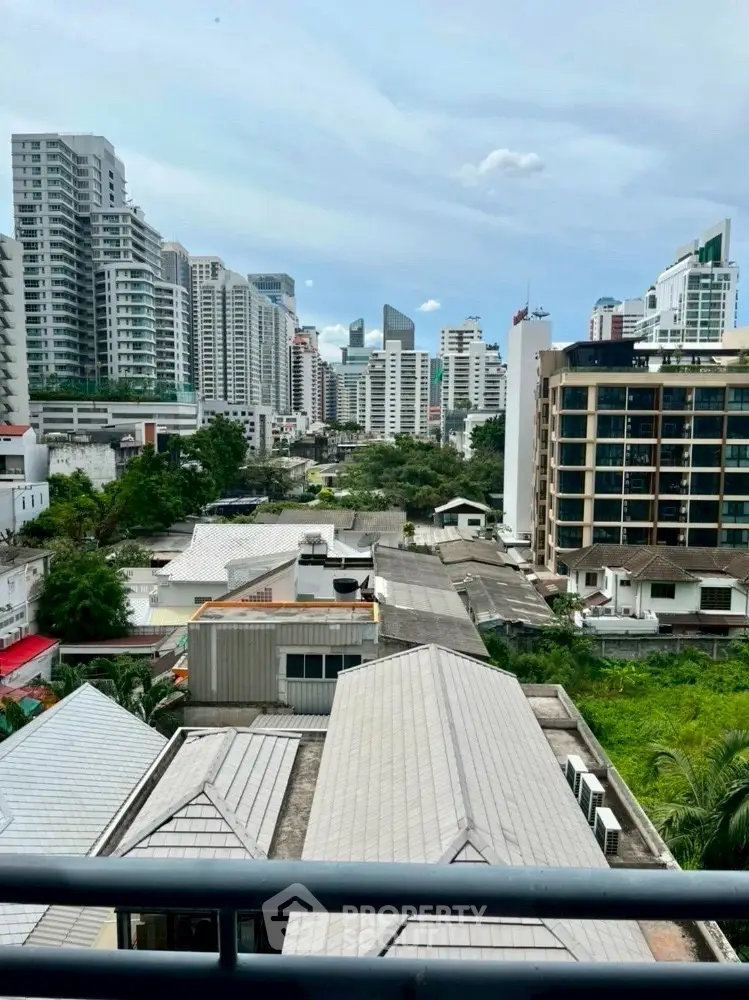 Stunning urban cityscape view from a high-rise balcony, showcasing modern architecture and lush greenery.