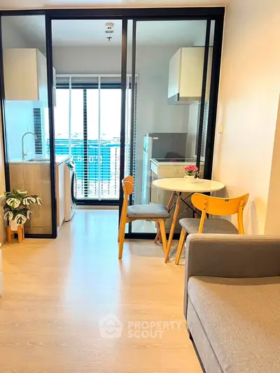Modern apartment interior with open kitchen and dining area, featuring stylish furniture and natural light.