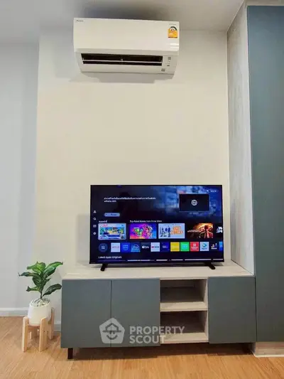 Modern living room with sleek TV unit and air conditioner, perfect for cozy entertainment.