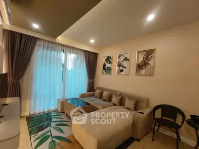 Elegant living room with modern decor, plush sofa, and large window for natural light.