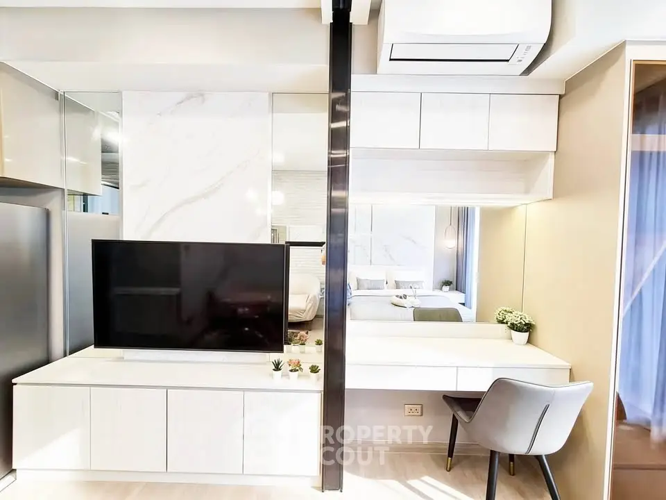 Modern living room with sleek TV unit and stylish workspace in a contemporary apartment.