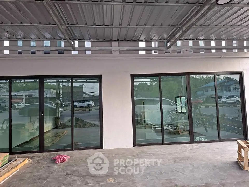 Modern building exterior with large glass doors and covered patio area.