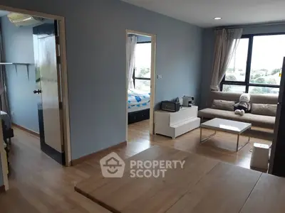 Modern apartment interior with cozy living room and bedroom, featuring large windows and stylish decor.