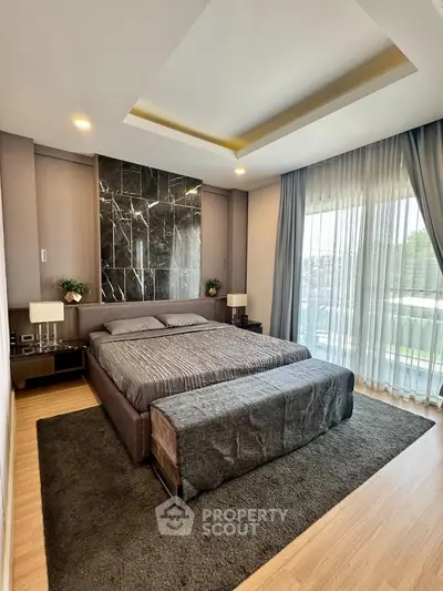 Luxurious bedroom with modern decor and large windows offering natural light and serene views.