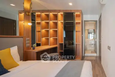 Modern bedroom with stylish wooden shelving and ensuite bathroom in luxury apartment.