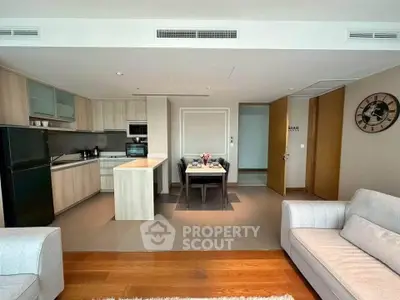 Modern open-plan living room and kitchen with stylish decor and ample natural light.