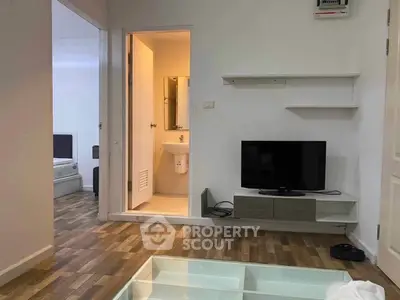 Modern apartment interior with living room and bathroom, featuring sleek wooden flooring and minimalist decor.