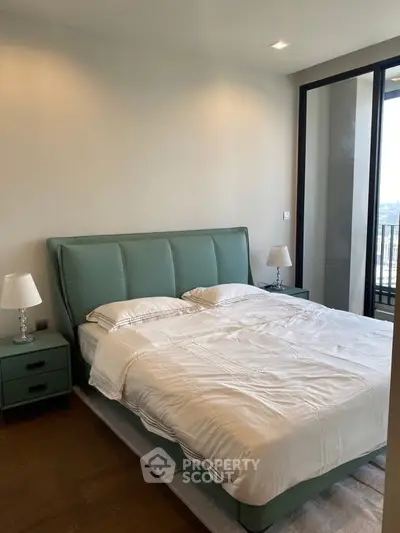 Modern bedroom with stylish green bed and large window offering natural light