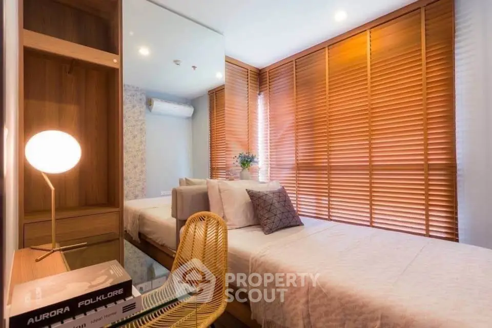 Cozy bedroom with modern decor and natural light through wooden blinds.