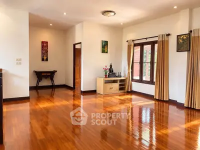 Spacious living room with polished wooden floors and elegant decor