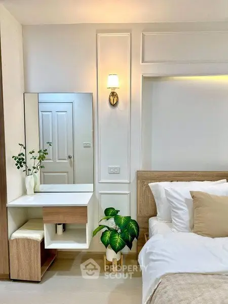 Elegant bedroom with modern decor, featuring a stylish vanity and cozy bed setup.