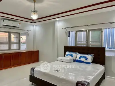 Spacious bedroom with modern decor and large windows for natural light.