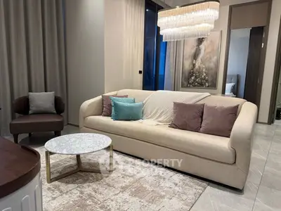 Luxurious modern living room with elegant chandelier and cozy seating area.