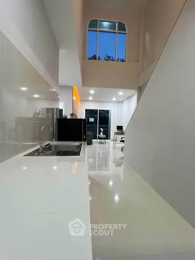 Stunning modern kitchen with sleek white countertops and high ceilings, perfect for contemporary living.