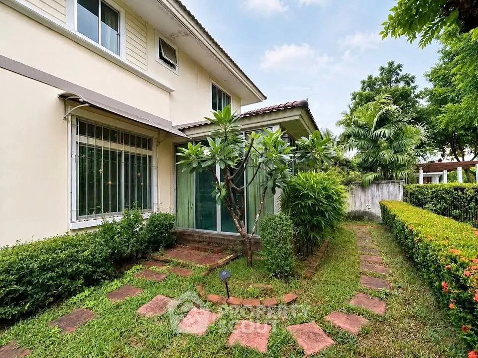 Charming suburban home with lush garden and paved walkway, perfect for family living.