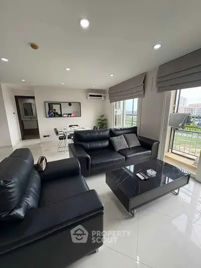 Modern living room with black leather sofas and city view