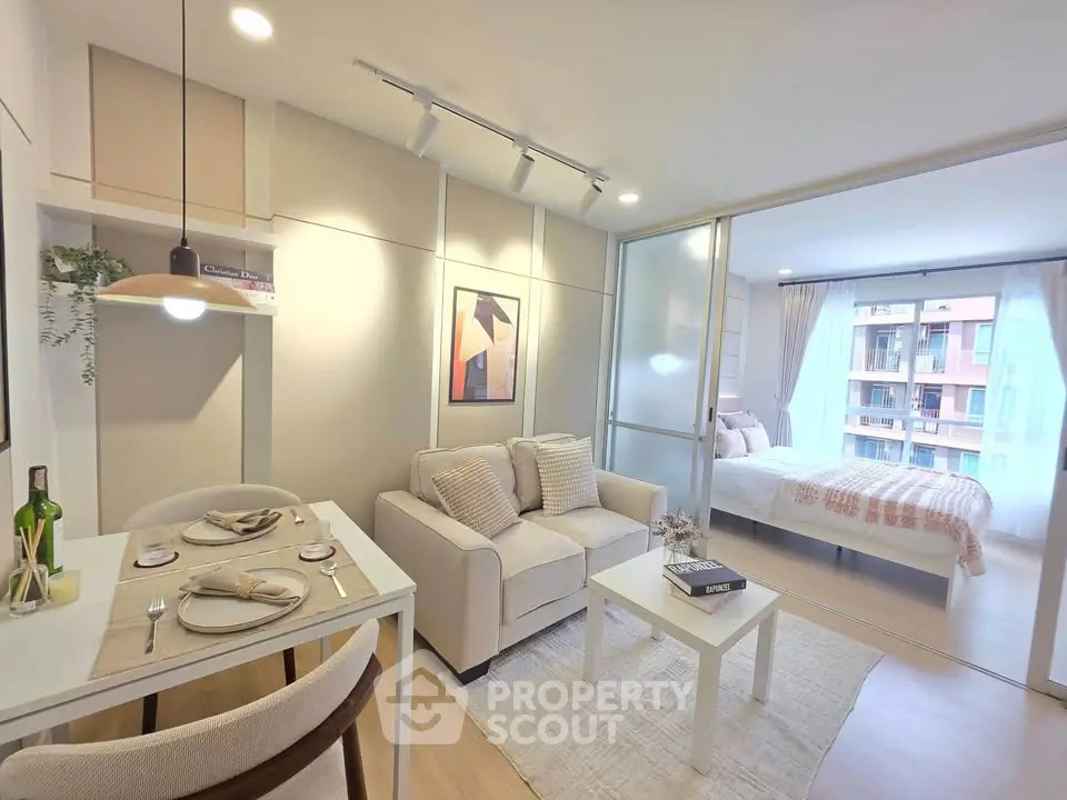 Modern open-plan living room with cozy dining area and sliding glass doors to bedroom.