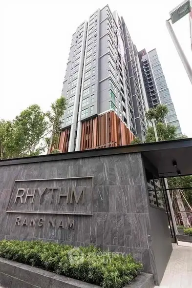 Modern high-rise building exterior with sleek design and lush greenery.