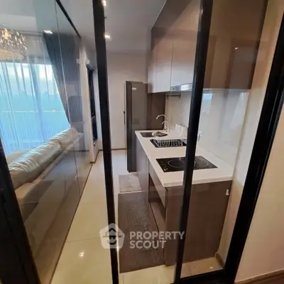 Modern kitchen with sleek design and glass partition in a stylish apartment.