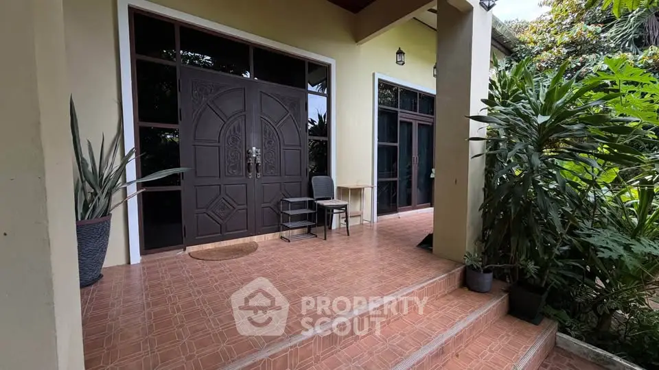 Charming entrance with elegant double doors and lush greenery, perfect for a welcoming home ambiance.