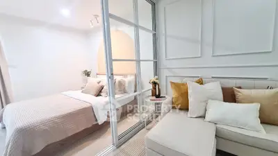 Modern bedroom with glass partition and cozy seating area, perfect for urban living.