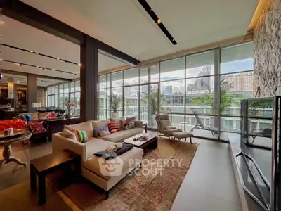 Luxurious living room with panoramic city views and modern decor in a high-rise apartment.