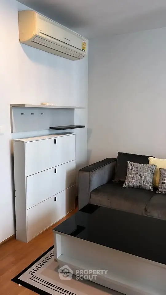 Modern living room with sleek furniture and air conditioning unit, perfect for urban living.